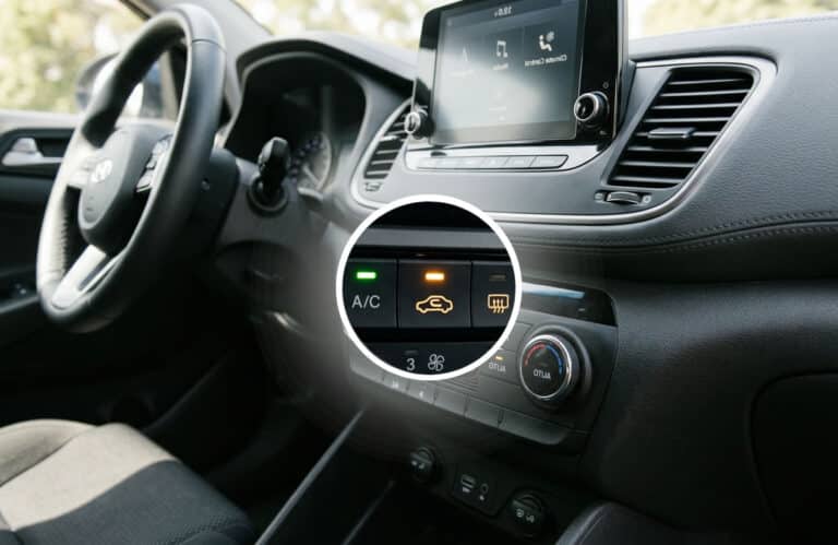 Interieur van een auto met zichtbare recirculatieknop van de airco